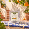 Raintree and Company 1oz Orange Grove wax melt on a Mediterranean-style courtyard table